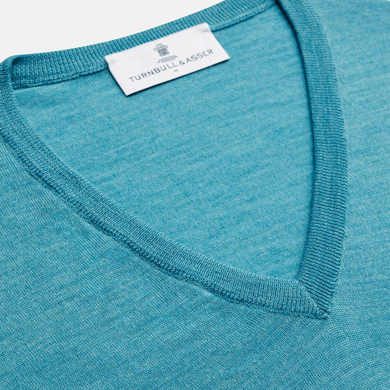 View 2 of product The Turquoise Kennedy Merino V-Neck Jumper by Turnbull & Asser features ribbed cuffs and hem, crafted from premium merino knitwear, and is shown flat on a white background.