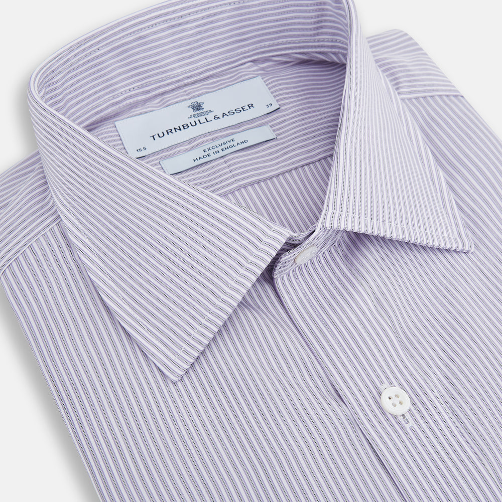 The Lilac Halo Stripe Mayfair Shirt by Turnbull & Asser features a relaxed Mayfair fit, white buttons, a pointed collar, and a subtle lilac stripe pattern for timeless sophistication.
