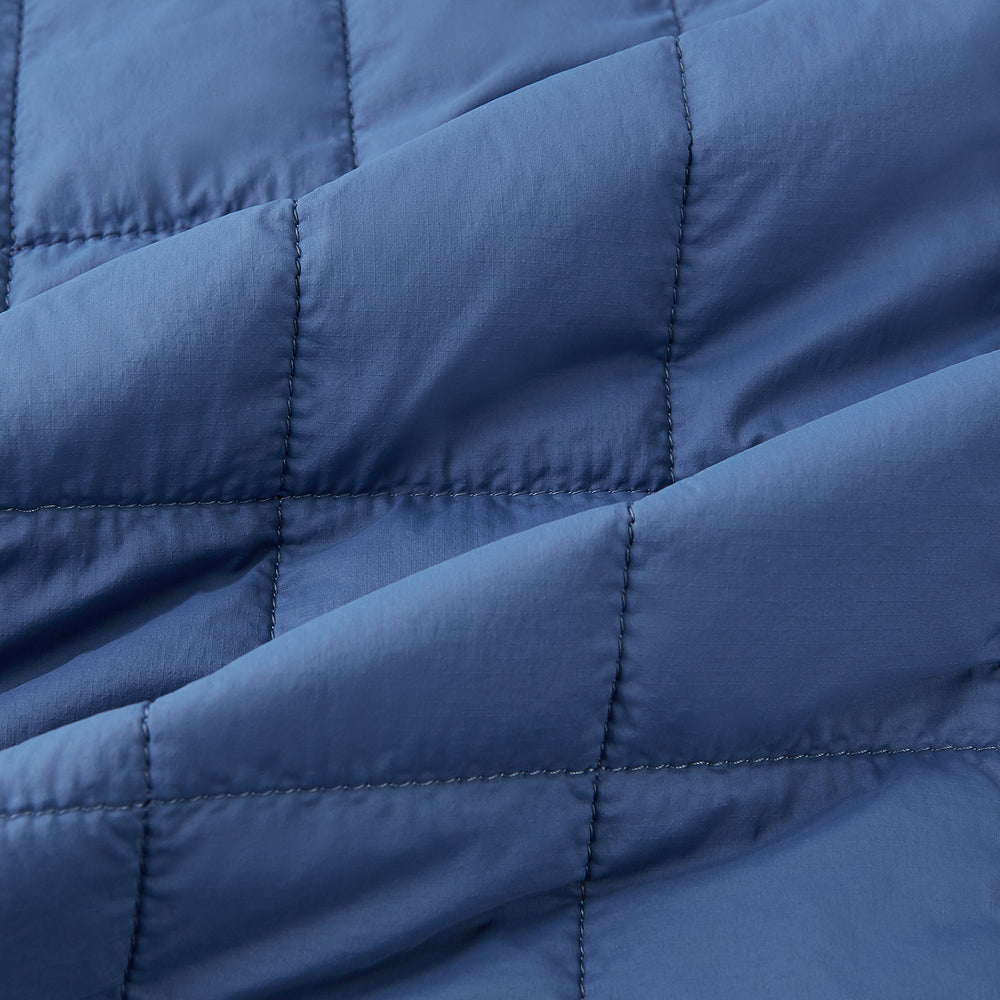 The Azzurro Quilted Gilet by Turnbull & Asser is a sleeveless, lightweight men’s outerwear piece featuring a front zipper, angled zippered pockets, and a chest pocket, shown against a plain white background.