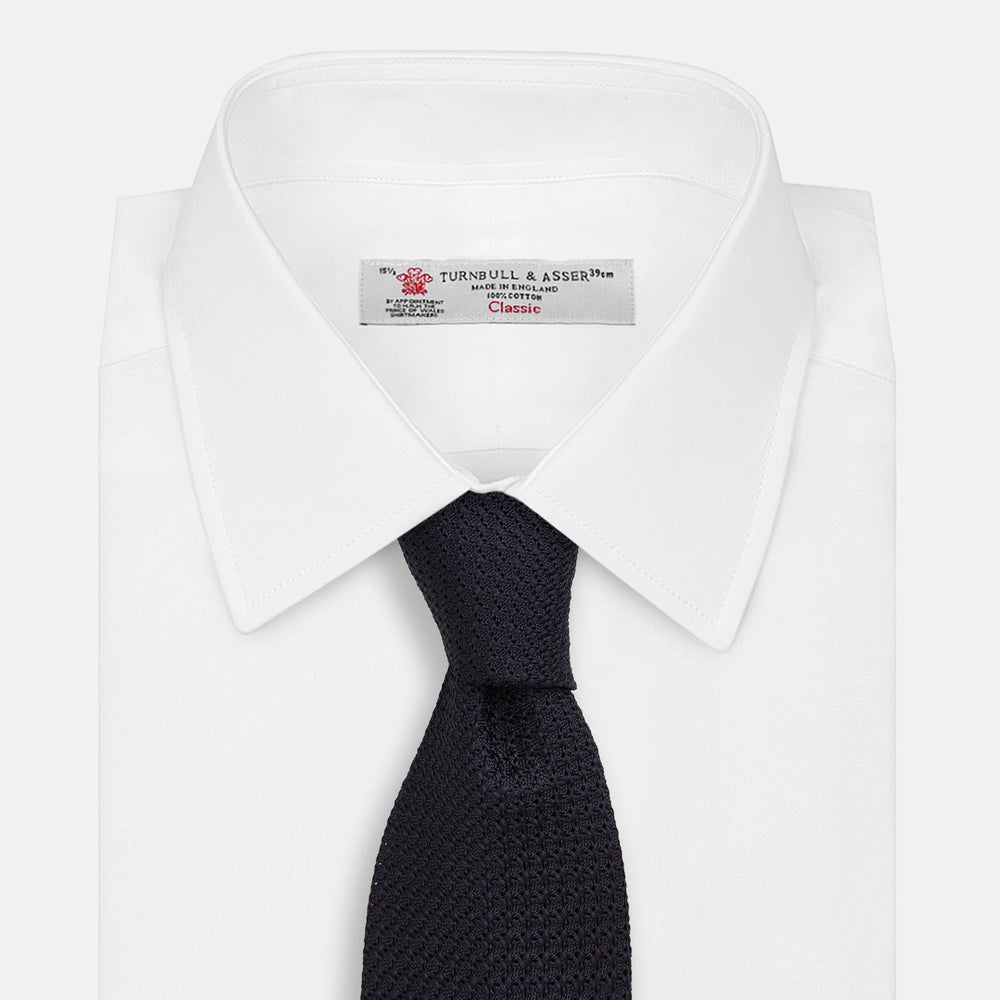 The Turnbull & Asser Midnight Blue Knitted Tie, elegantly textured and displayed on a white background, is a versatile addition to any gentleman's wardrobe.