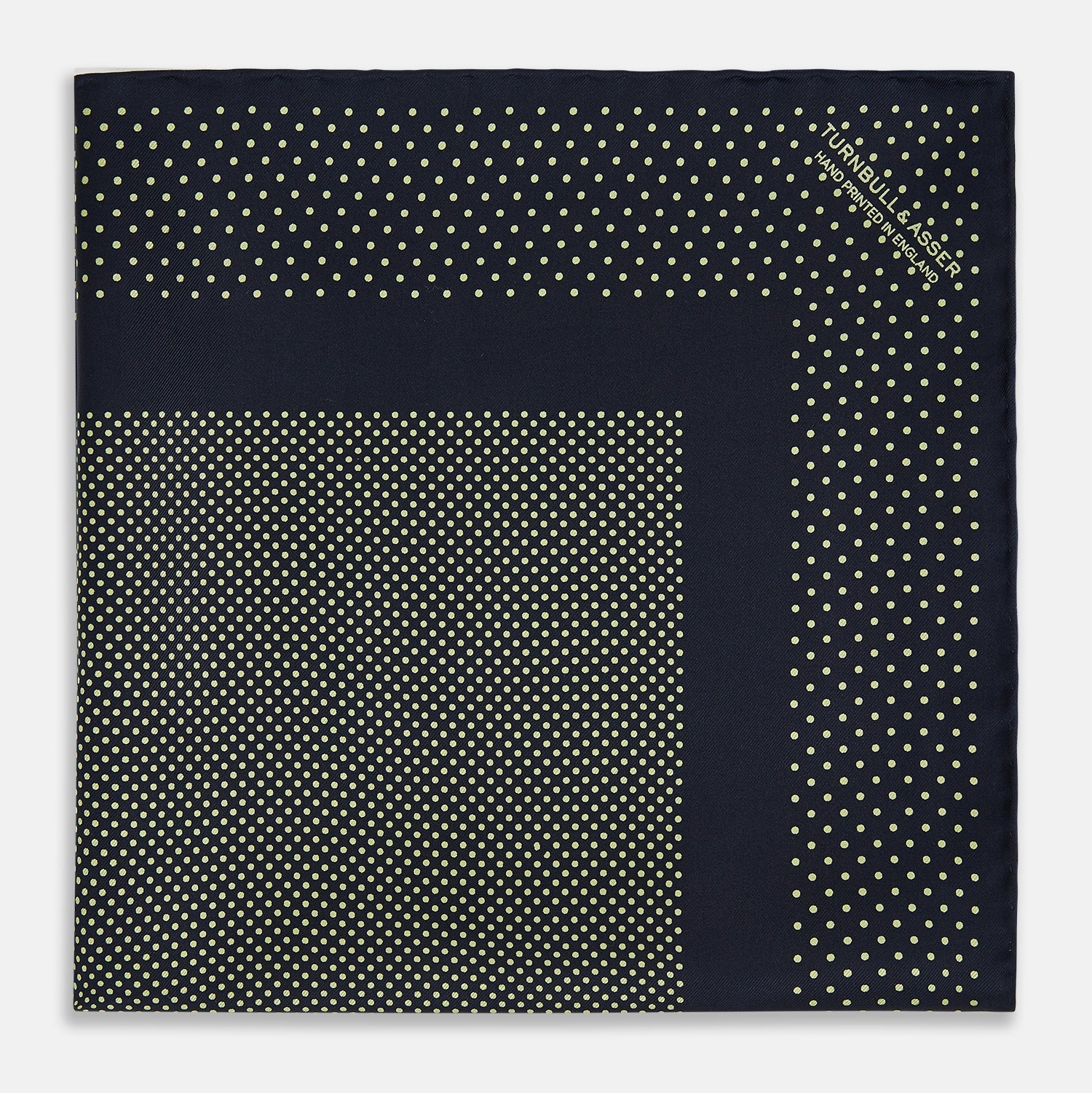 View 3 of product The Turnbull & Asser Navy and Gold Silk Pocket Square is handmade, featuring small gold polka dots on navy with a solid border, displayed neatly folded with one corner turned up.