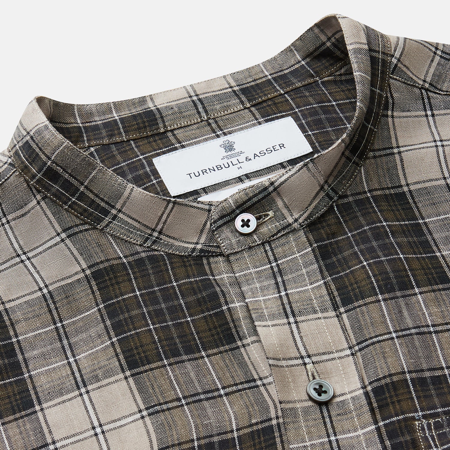 View 2 of product The Brown Multi Check Linen Weekend Fit Unwin Shirt by Turnbull & Asser features a beige, brown, and black plaid pattern, stand collar, button-up front, long sleeves, and two buttoned chest pockets.