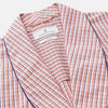 View 3 of product The Turnbull & Asser Orange Multi Check Cotton Arnold Gown features long sleeves, a shawl collar, wrap-around belt, and dark piping on the edges and pocket, displayed flat on a white background.