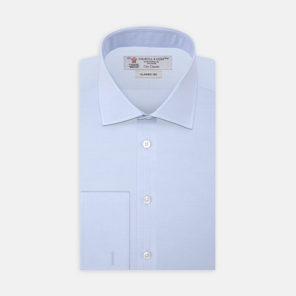 A neatly folded Turnbull & Asser Two-Fold 120 Light Blue Shirt, featuring a regent collar and double cuffs, is displayed against a plain white background.