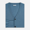 View 4 of product The Turnbull & Asser Pale Blue Fine Merino V-Neck Cardigan features long sleeves and five black buttons, showcased on a plain white background.