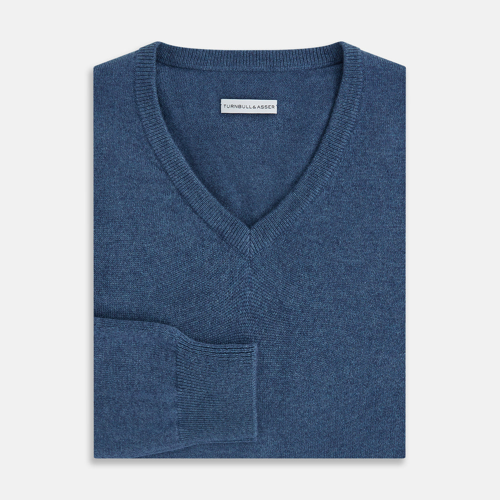 Turnbull & Asser’s Pacific Blue Cashmere V-Neck Jumper features ribbed cuffs, hem, and neckline, shown on a white background.