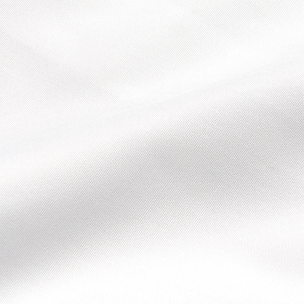 A woman stands in profile, looking down with hands in her pockets, wearing the Turnbull & Asser Turnbull and The Deck White Cotton Expressionist Shirt, paired with high-waisted black-and-white houndstooth pants.