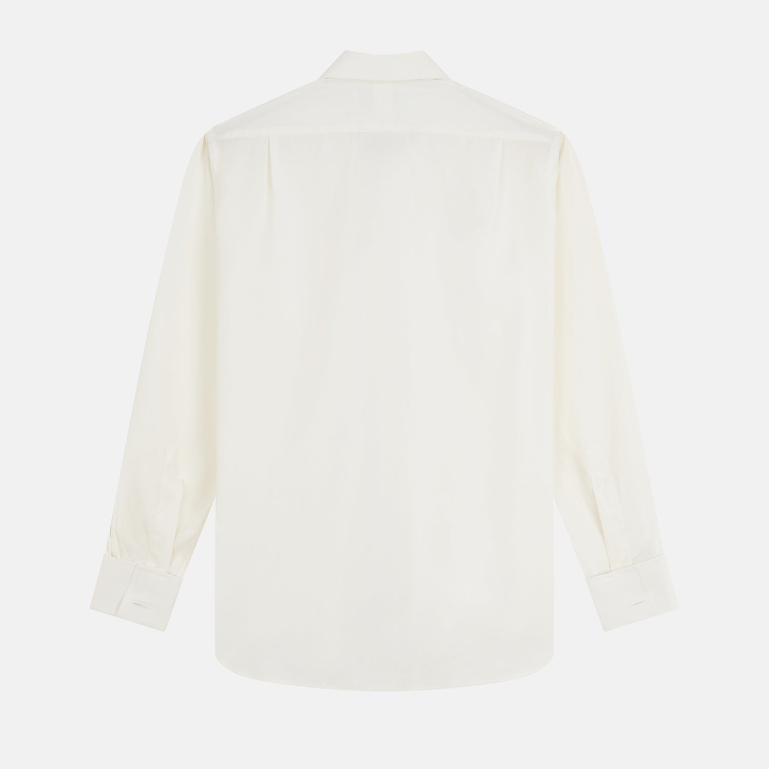 View 6 of product A man in a Cream Silk Regular Fit Ruffle-Front Wilfred Shirt by Turnbull & Asser stands against a dark background, one hand on a chair, gazing thoughtfully to the side.
