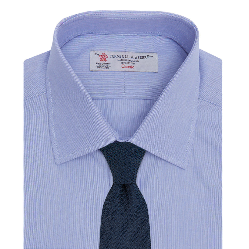 The Turnbull & Asser Blue Hairline Stripe Shirt features a T&A collar, 3-button cuffs, and subtle stripes, displayed neatly folded against a plain white background.
