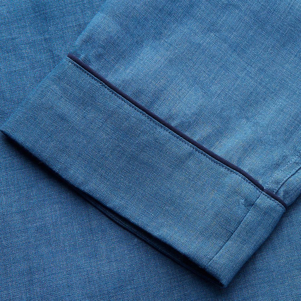 A person stands barefoot against a plain background, wearing the Teal Linen Modern Pyjama Set from Turnbull & Asser.
