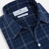 View 2 of product The Indigo and White Thin Plaid Check Windsor Shirt by Turnbull & Asser, a long-sleeve button-up with white buttons, is shown laid flat on a white background.