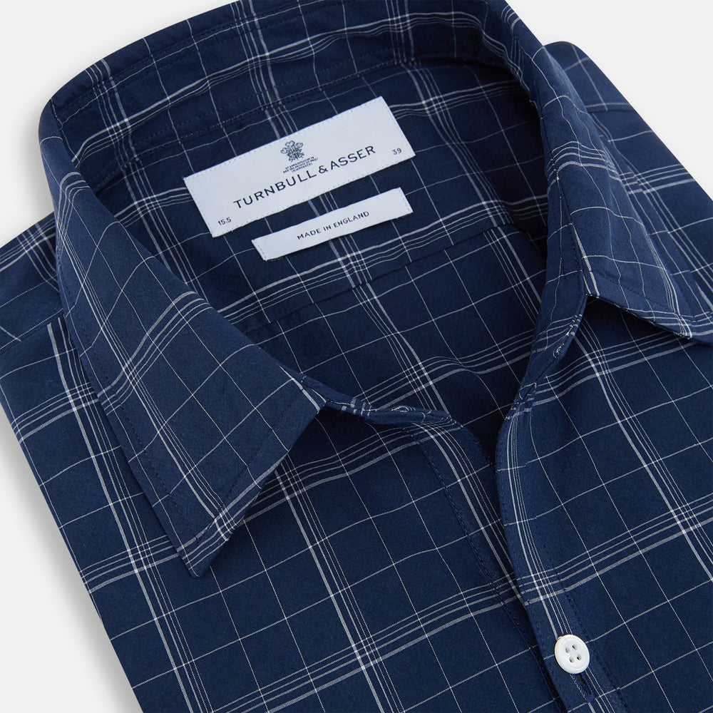 The Indigo and White Thin Plaid Check Windsor Shirt by Turnbull & Asser, a long-sleeve button-up with white buttons, is shown laid flat on a white background.
