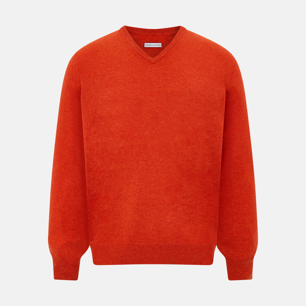 The Turnbull & Asser Red Orange Cashmere V-neck Jumper features long sleeves, ribbed cuffs and hem, displayed on a plain white background—a stylish knitwear essential for any wardrobe.