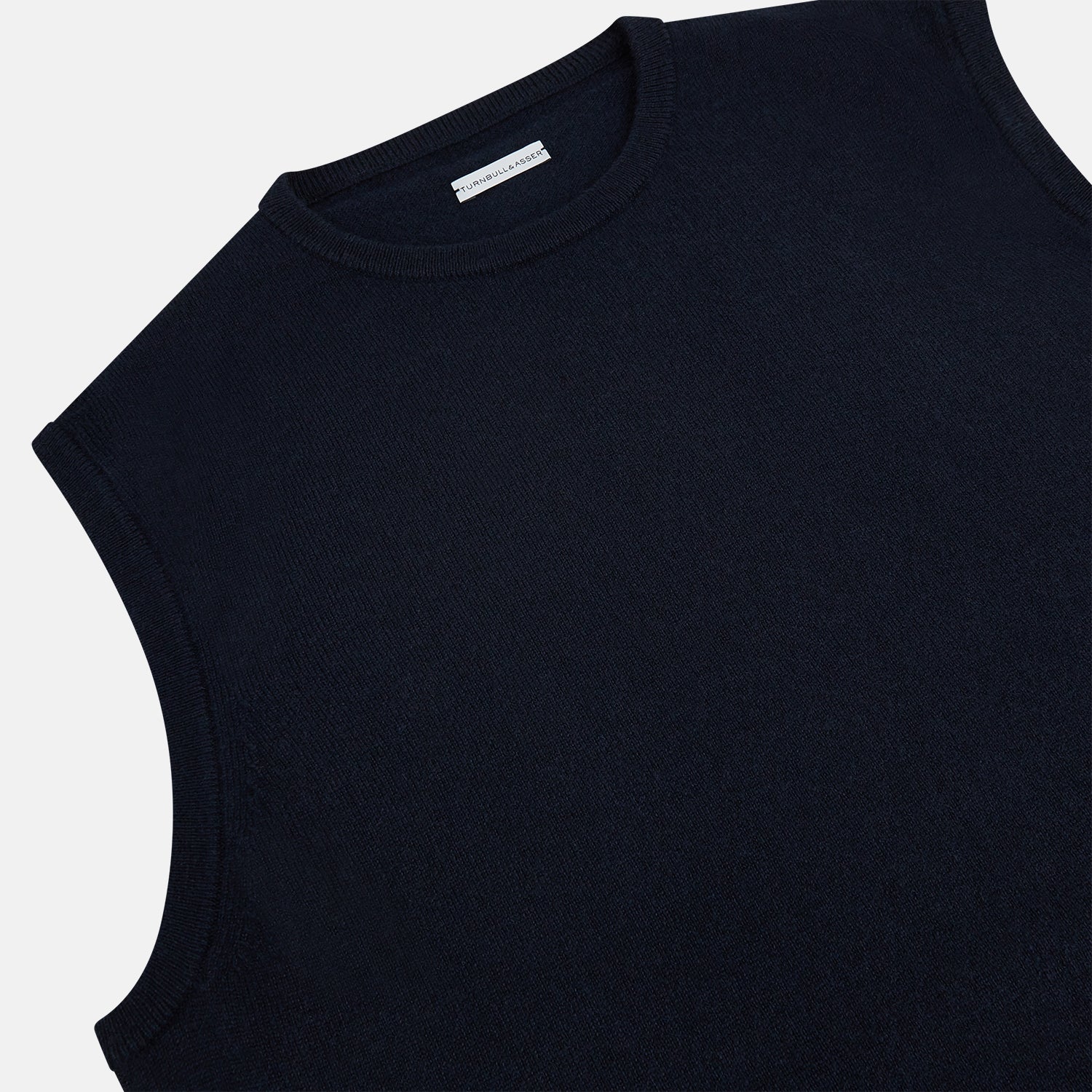 View 2 of product The Navy Cashmere Round Neck Vest by Turnbull & Asser is an elegant men's sleeveless knit, featuring a crew neck and ribbed hem. Perfect as a light layer, it is displayed against a plain white background.