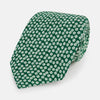 View 1 of product The Forest Green Flower Patterned Silk Tie by Turnbull & Asser features a white floral motif on silk, shown neatly rolled against a plain white background.
