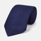 The PLAIN HERRINGBONE NAVY TIE by Turnbull & Asser, crafted from silk with a subtle pattern, is elegantly rolled and displayed against a plain white background.