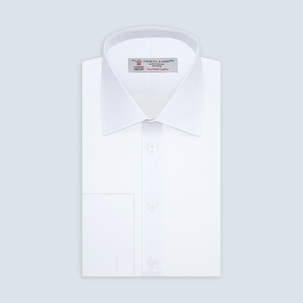 A neatly folded White Sea Island Quality Cotton Twill Shirt by Turnbull & Asser, featuring a T&A collar and 3-button cuffs, is displayed on a light grey background with a label visible inside the collar.