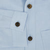 View 4 of product The Turnbull & Asser Pale Blue Hyde Overshirt is a long-sleeve, sanforised cotton button-up with a single chest pocket and dark buttons, shown on a plain white background.