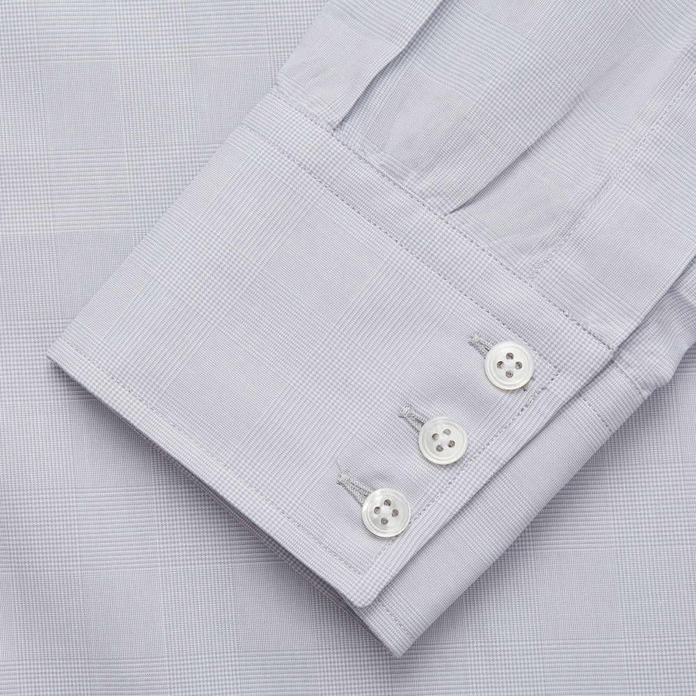 The Turnbull & Asser Faded Blue Block Check Cotton Regular Fit Mayfair Shirt, featuring long sleeves, a classic collar, and white buttons, is neatly laid flat on a white background.