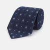 View 1 of product The Turnbull & Asser Jacquard Silk Circle Tie showcases a textured navy blue design with small white and light blue floral motifs—an essential accessory for refined attire.