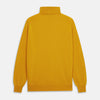 View 5 of product A man with short hair and a beard wears the Gold Aubrey Cashmere Roll Neck Jumper by Turnbull & Asser with dark pants, standing against a plain beige background and calmly looking at the camera, highlighting this stylish autumn sweater look.