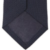 View 3 of product The Turnbull & Asser Plain Woven Grenadine Silk Tie in navy, with a textured finish, is rolled and displayed on a white background—a refined essential for any wardrobe.