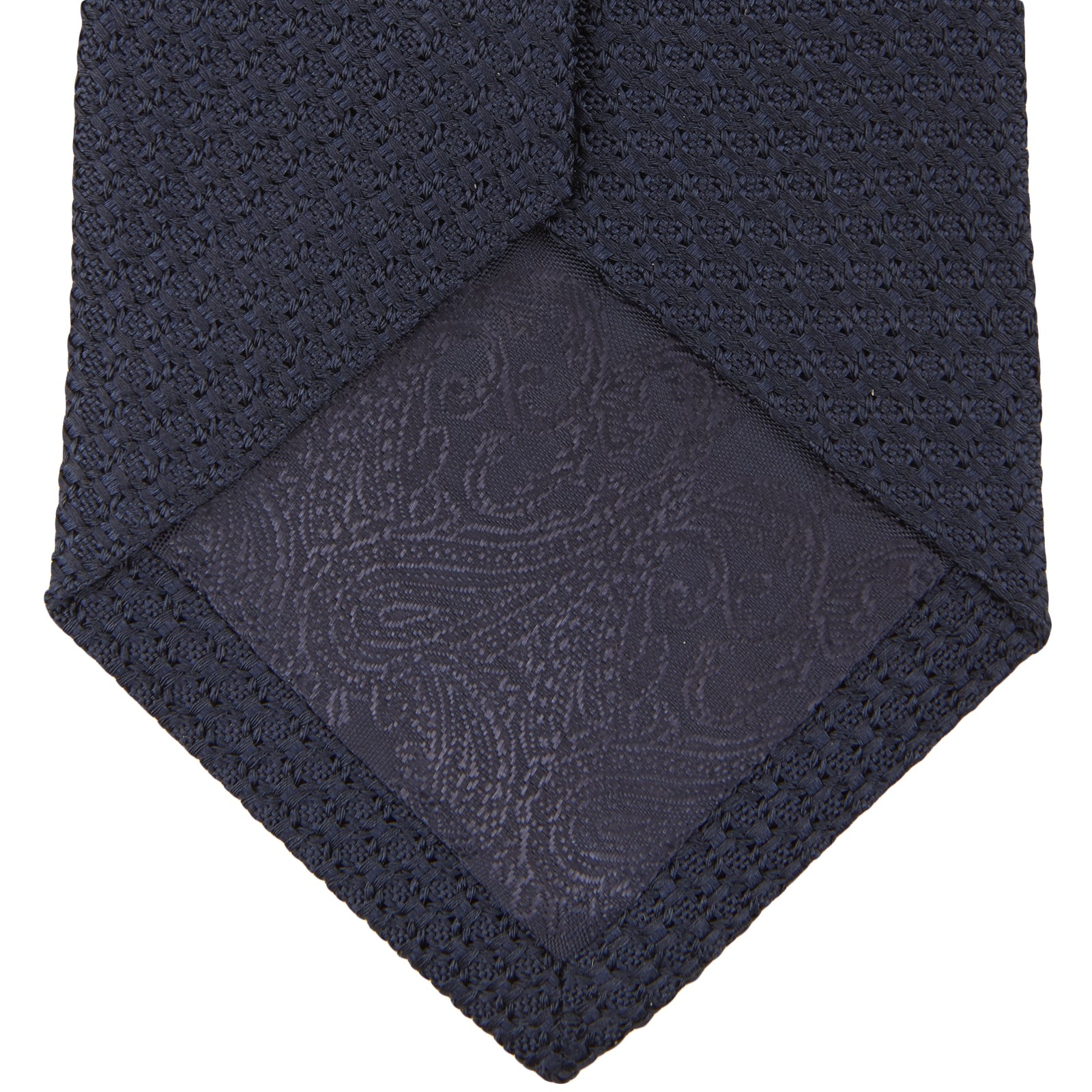 View 3 of product The Turnbull & Asser Plain Woven Grenadine Silk Tie in navy, with a textured finish, is rolled and displayed on a white background—a refined essential for any wardrobe.