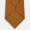 View 3 of product The Turnbull & Asser Purple and Orange Micro Dot Silk Tie features a pattern of small blue dots, shown rolled up on a white background.