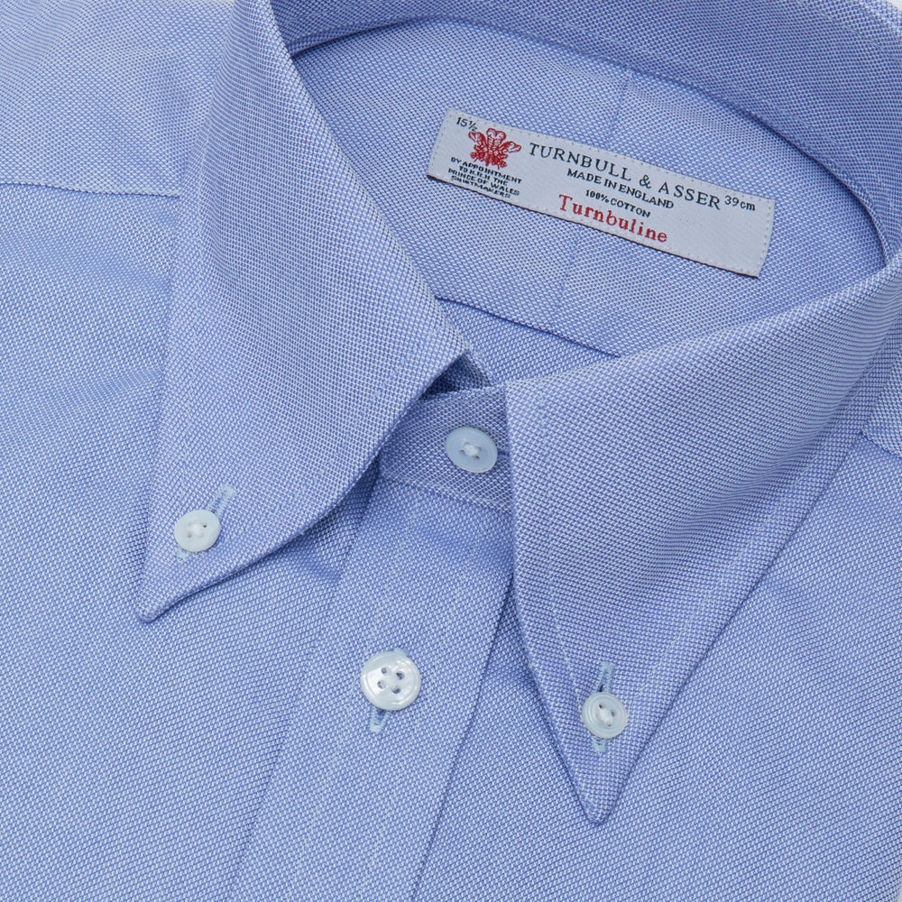 The Turnbull & Asser Blue Royal Oxford Cotton Shirt features a button-down collar, 3-button cuffs, and a visible brand label, shown neatly folded on a white background—ideal for pairing with a navy suit.
