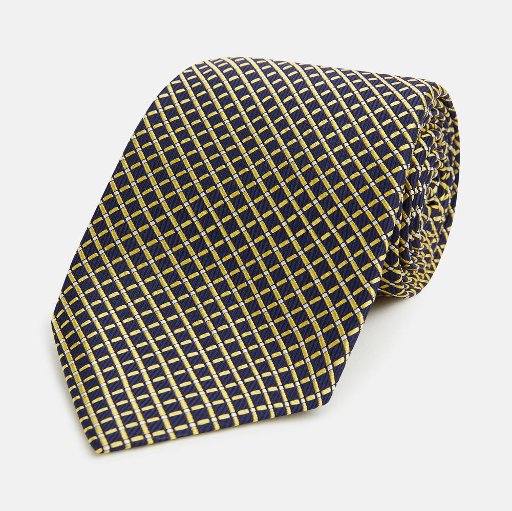 The Turnbull & Asser Yellow and Navy Diamond Silk Tie, with a refined yellow and light blue grid pattern, is elegantly rolled up on a plain white background.