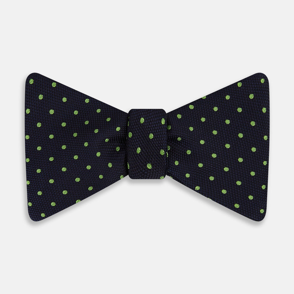 The Turnbull & Asser Lime Green and Navy Micro Dot Silk Bow Tie features small lime green dots on navy silk, displayed against a plain white background.
