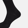 View 4 of product The Turnbull & Asser Black Wool Long Sock stands upright on a white background, featuring a ribbed texture with a fitted foot and calf, ideal for those seeking stylish over the calf socks.