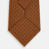 View 3 of product The Turnbull & Asser Purple and Orange Micro Dot Silk Tie, featuring a vibrant polka dot pattern, makes a bold men's accessory and is shown rolled up on a white background.
