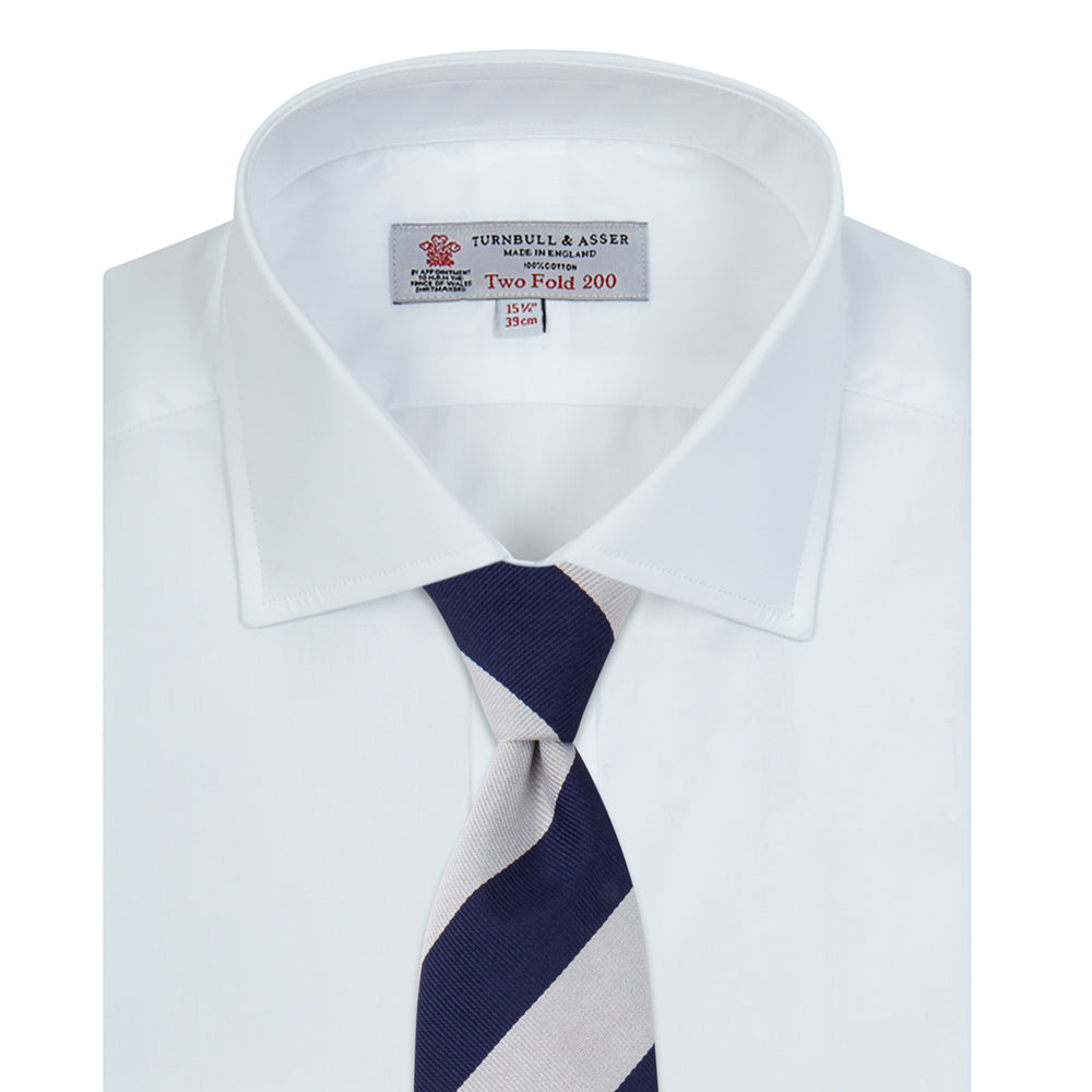 A neatly folded Turnbull & Asser Two-Fold 200 White Cotton Shirt with a Regent collar and 3-button cuffs, crafted from breathable fabric, is displayed on a light grey background with the label visible inside the collar.