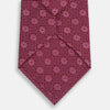 View 3 of product The Turnbull & Asser Burgundy Medallion Silk Tie features a geometric pattern of small circles intersected by diagonal pink lines, elegantly displayed against a white background.