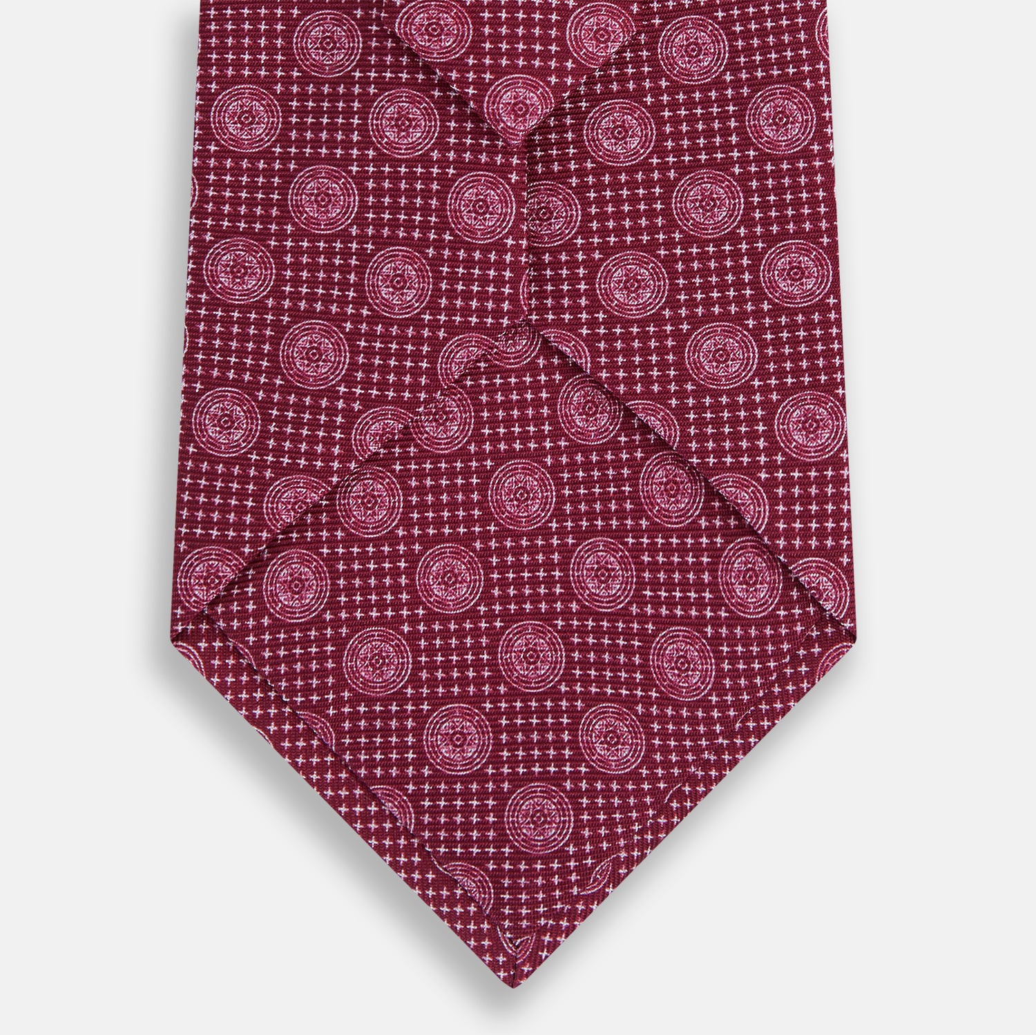 View 3 of product The Turnbull & Asser Burgundy Medallion Silk Tie features a geometric pattern of small circles intersected by diagonal pink lines, elegantly displayed against a white background.