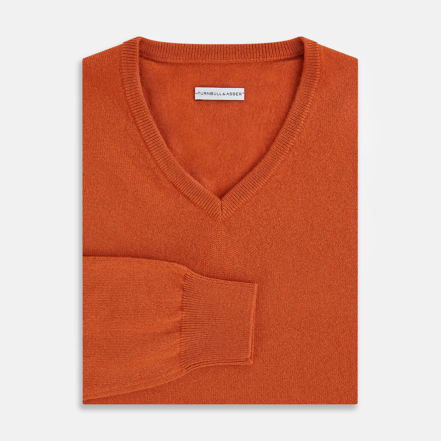 View 4 of product The Turnbull & Asser Rust Cashmere V-neck Jumper features long sleeves, ribbed cuffs and hem, and is shown against a plain white background.