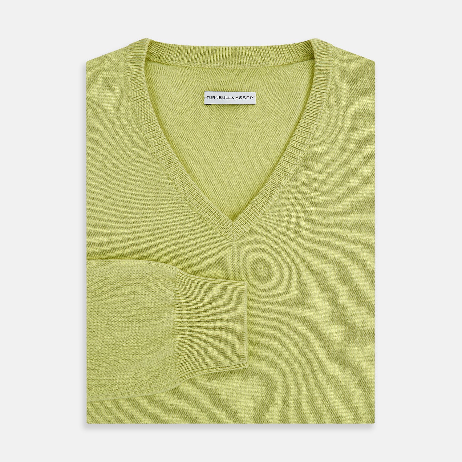 View 4 of product The Turnbull & Asser Melon Green Cashmere V-Neck Jumper features long sleeves with ribbed cuffs and hem, shown against a plain white background.