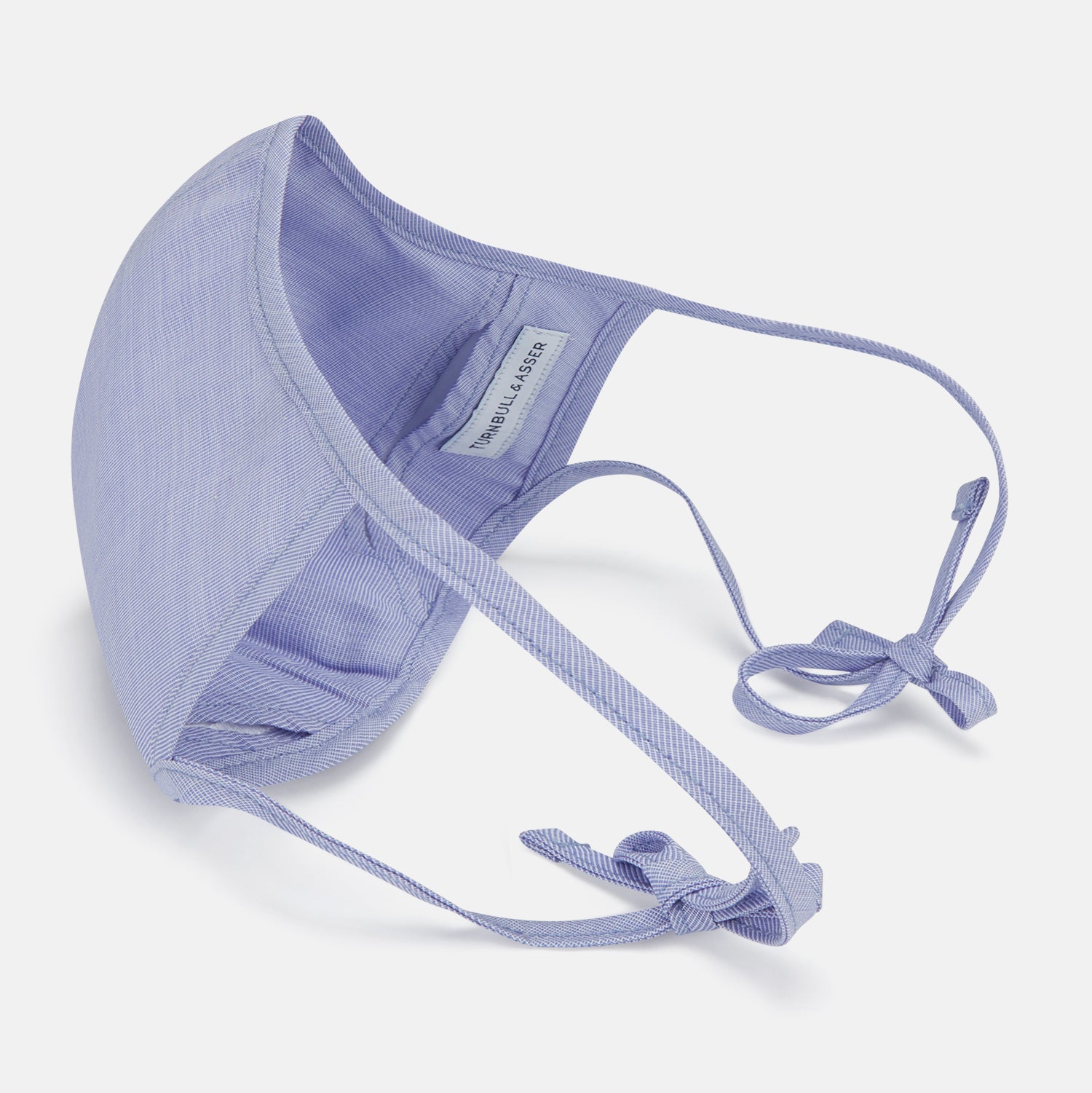 View 4 of product The Turnbull & Asser Plain Pale Blue Commuter Mask with 3 Viroformula™ filters features adjustable ear loops and side ties—ideal for daily use, shown against a white background.