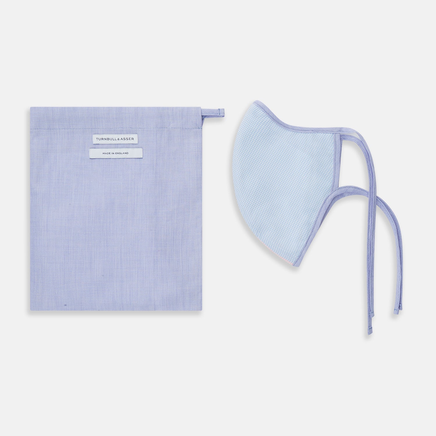 View 2 of product The Turnbull & Asser Pink & Blue Check Commuter Mask features lavender adjustable ear loops tied in bows and comes with 3 Viroformula™ filters. Shown on a plain white background.