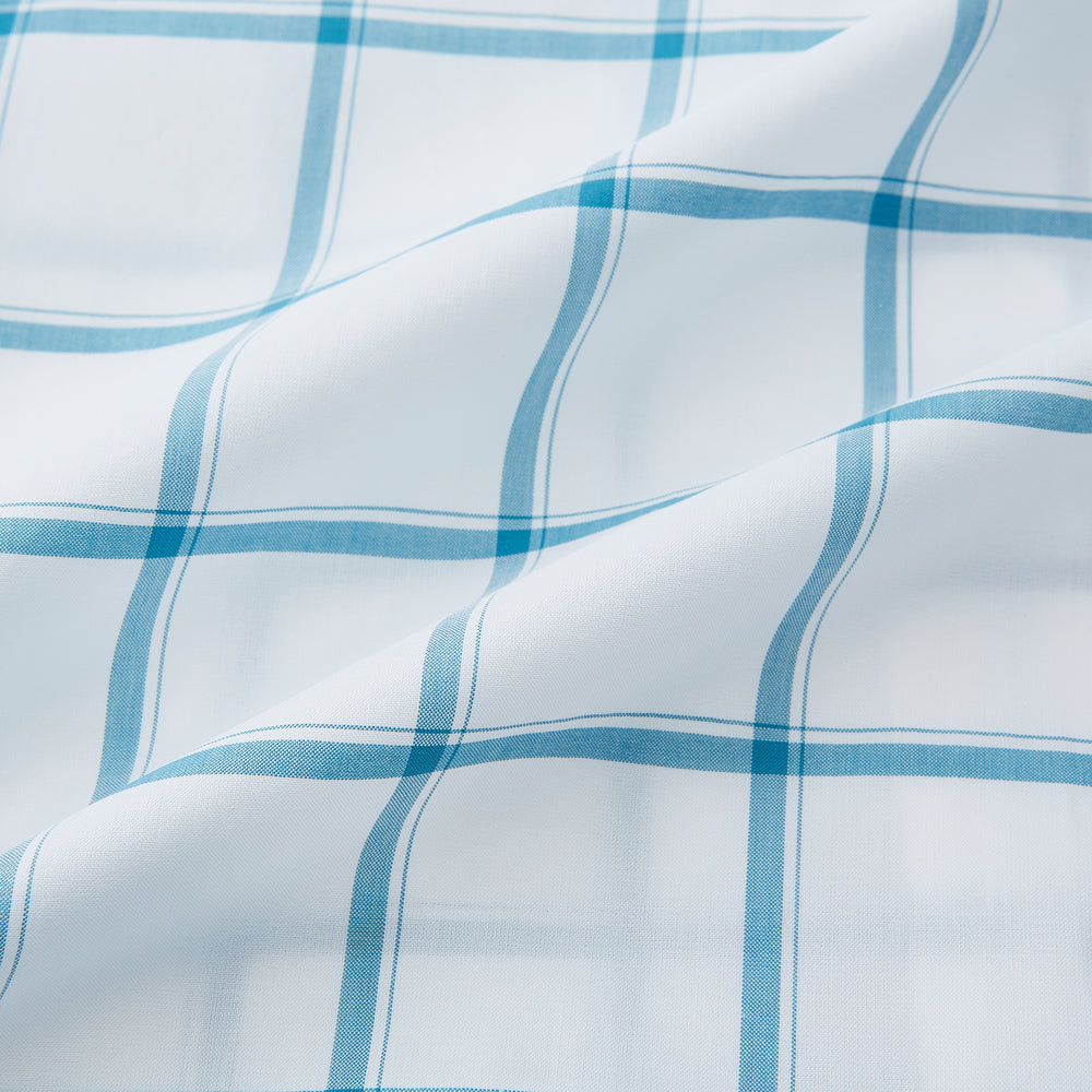 The Turnbull & Asser Turquoise Grid Check Mayfair Shirt is crafted from Italian cotton with a white base and turquoise grid pattern, featuring long sleeves, a pointed collar, and buttoned cuffs.