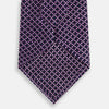 View 3 of product A rolled-up Turnbull & Asser Purple and Navy Diamond Silk Tie displays its elegant grid pattern of light pink and white lines on a white background.