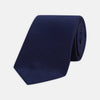 View 1 of product The Turnbull & Asser Seven-Fold Navy Lace Silk Tie is shown on a white background, rolled at one end with the pointed tip facing forward.