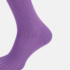 View 4 of product The Turnbull & Asser Violet Long Sock, crafted from mercerised Egyptian cotton, is shown in side profile against a white background, highlighting its knee-high length and ribbed texture.