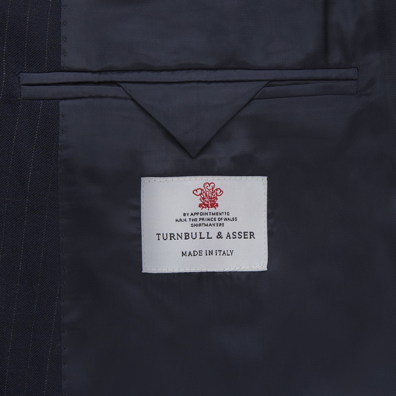 View 4 of product The Turnbull & Asser Navy Wool Pinstripe Double-Breasted Jacket features peak lapels, four front buttons, and three front pockets, and is displayed on a plain white background.
