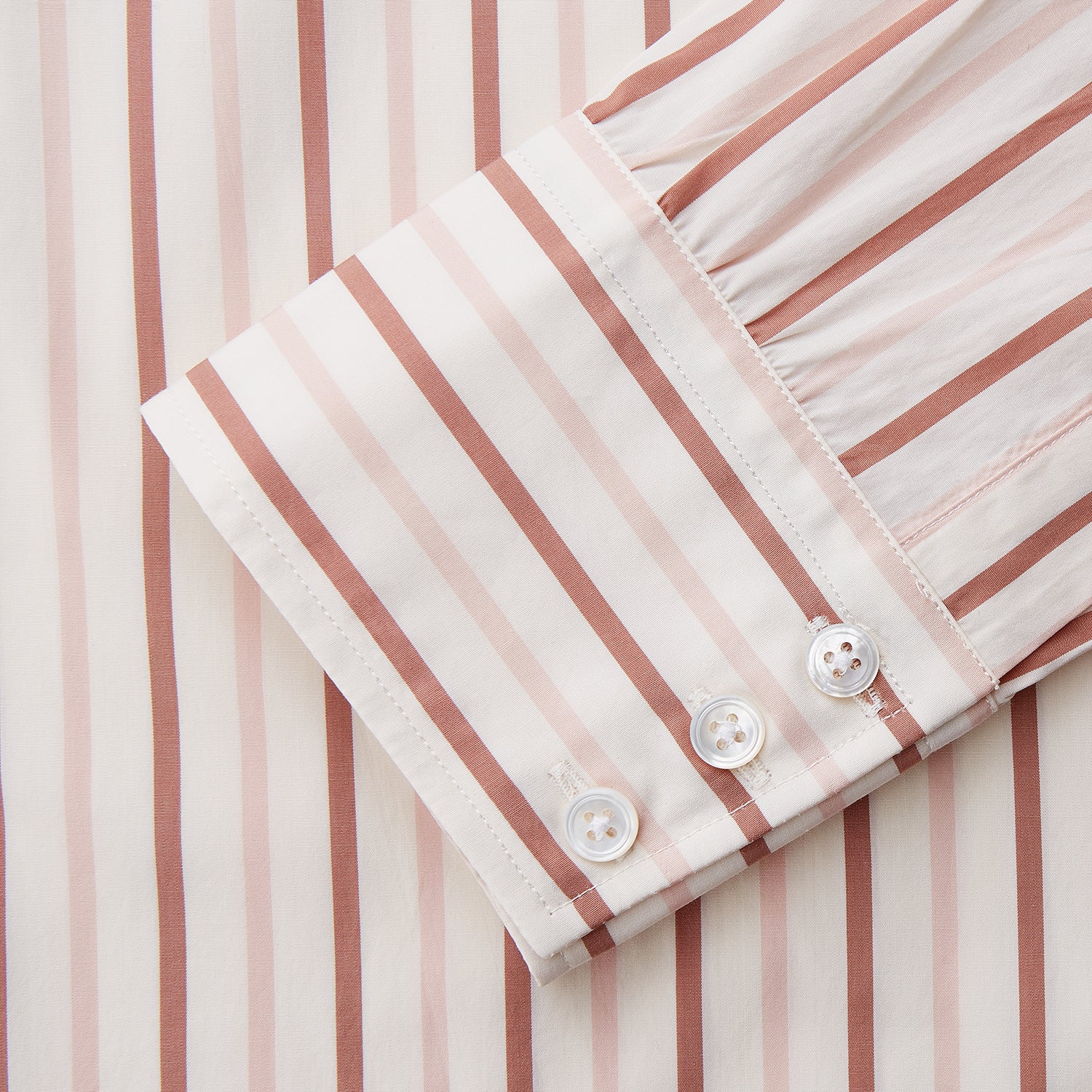 View 3 of product The Pink and Sandstone Stripe Cotton Regular Fit Mayfair Shirt by Turnbull & Asser features vertical pink and sandstone stripes on white, a T&A collar, wide cuffs, and a slightly curved hem for refined detail.
