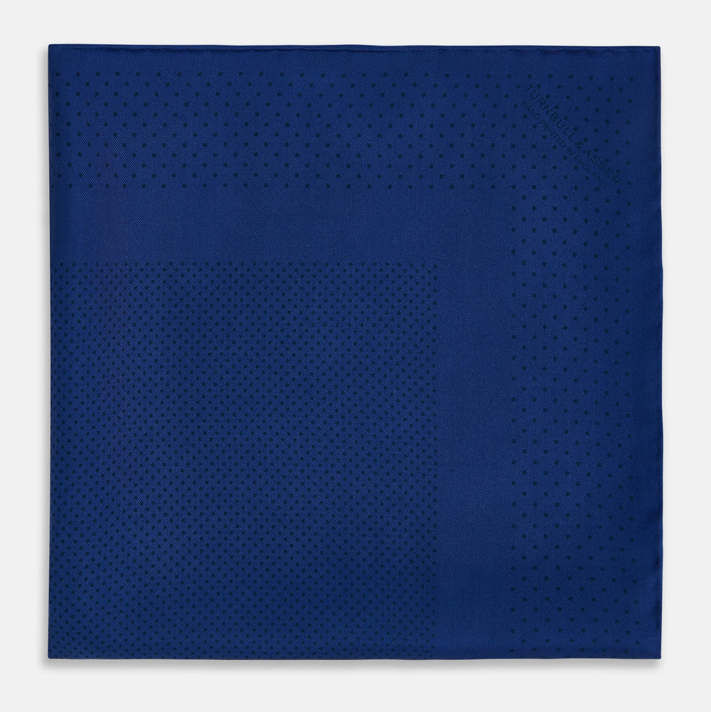 The Turnbull & Asser Navy Dot Silk Pocket Square, folded with neat hand-rolled edges, features a subtle navy polka dot pattern on dark blue silk and is shown against a white background.