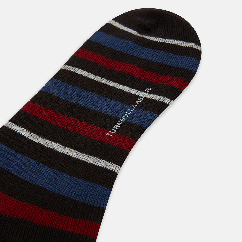 The Turnbull & Asser Dark Chocolate Striped Merino Wool Long Socks are knee-high, featuring horizontal black, red, blue, and gray stripes on a white background.
