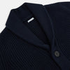 View 2 of product The Turnbull & Asser Midnight Blue Cashmere Shawl Collar Cardigan features ribbed fabric, five black front buttons, a shawl collar, and two front patch pockets, shown against a plain light background.
