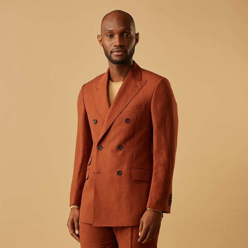 The Turnbull & Asser Rust Linen-Wool-Silk Bertie Blazer is a red double-breasted jacket with peak lapels, black buttons, and flap pockets, tailored in Italy from a luxury linen-wool-silk blend and shown on a white background.